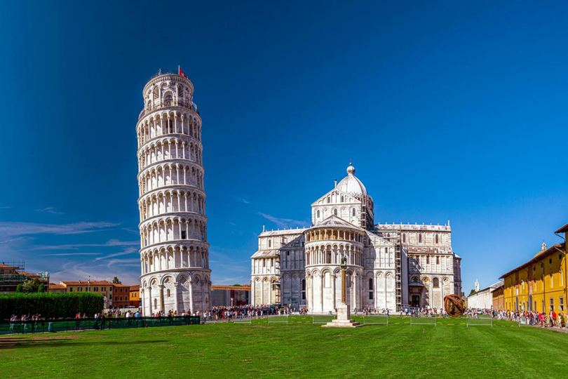 La torre inclinada y la catedral de Pisa sobre el césped de la Piazza dei Miracoli, Italia